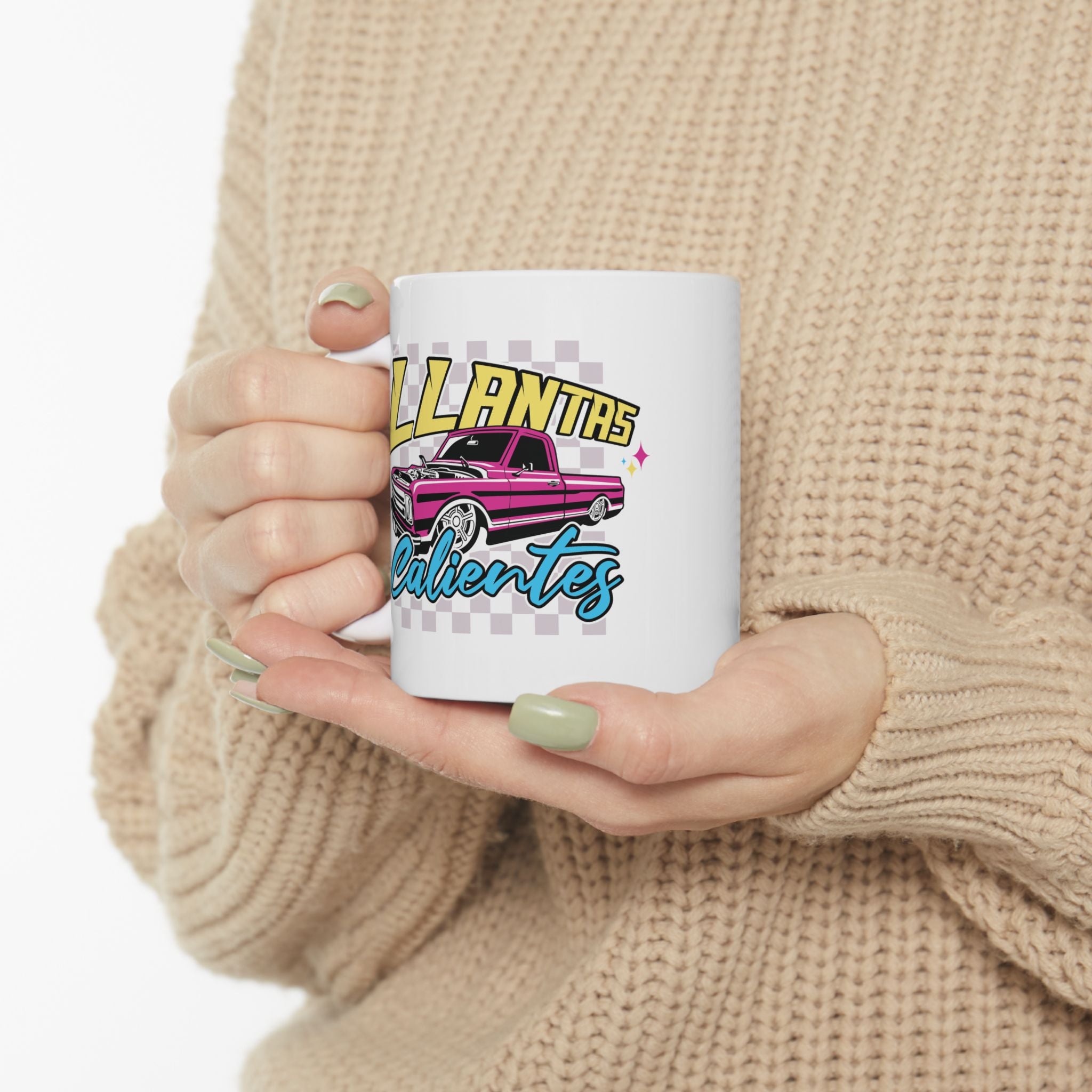 Close-up of Llantas Calientes ceramic mug with vibrant pink retro truck design