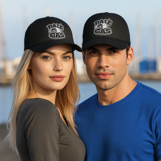 Two people wearing black caps with 'Dale of Gas' logo against a blurred outdoor background