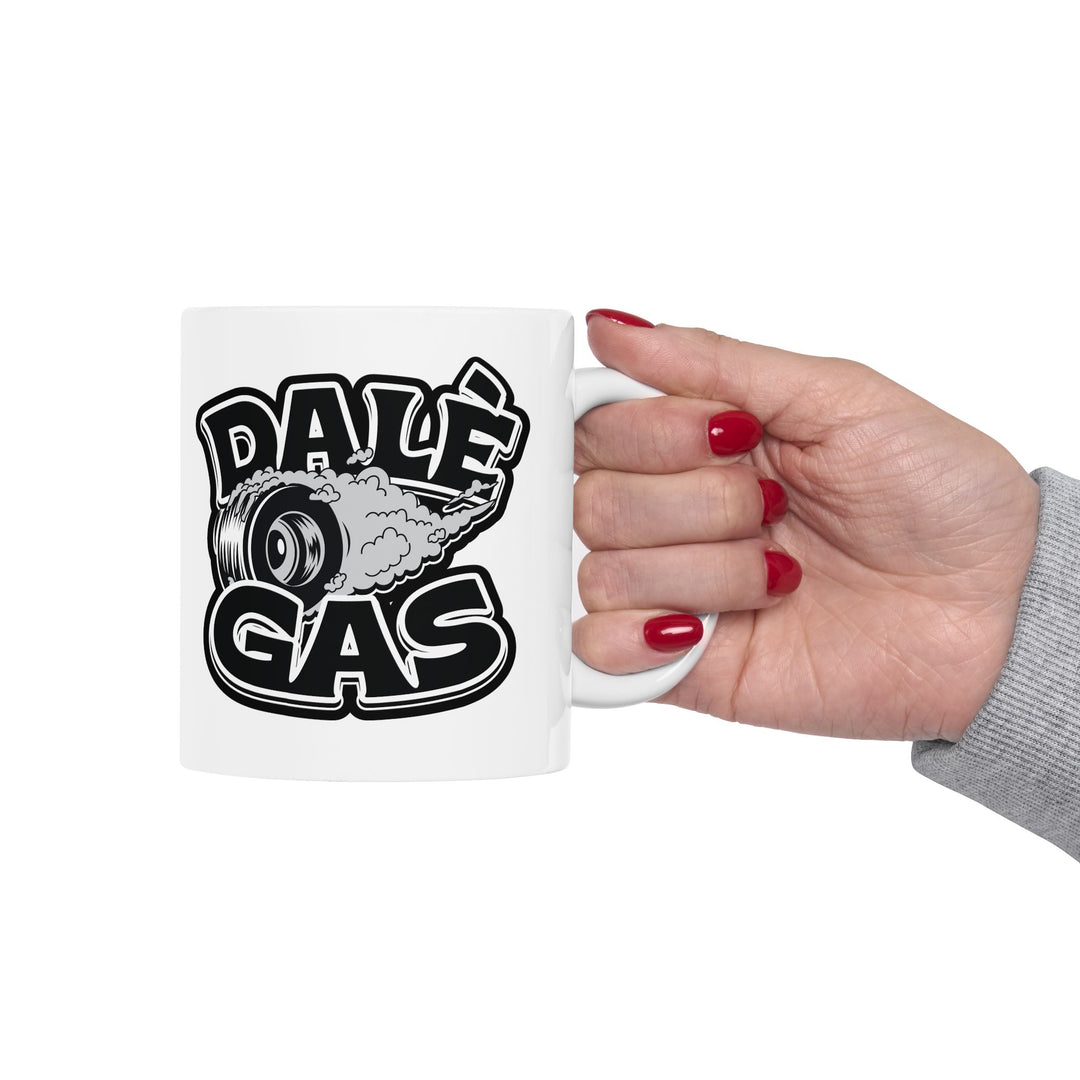 White mug with 'Dale Gas' graphic held by a hand with red nail polish on a white background