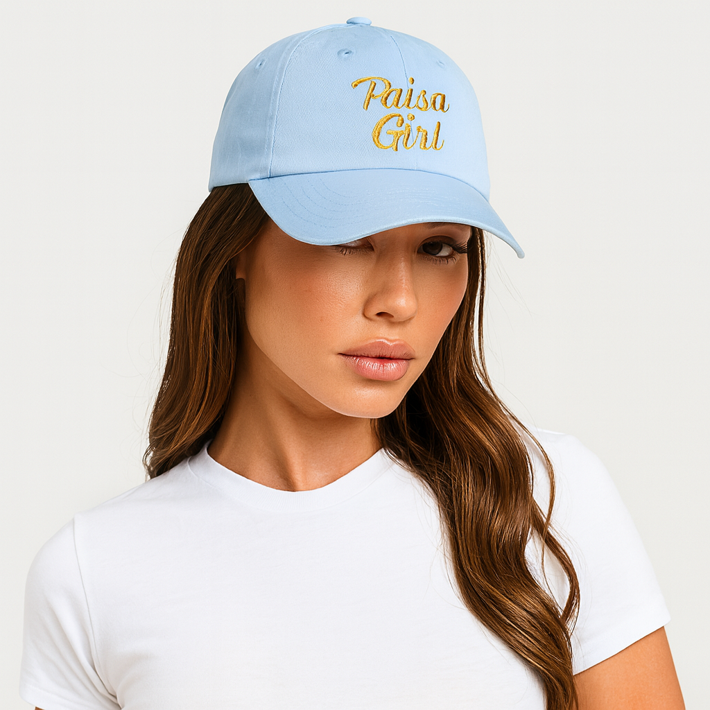 Fashion editorial photo of young Hispanic woman wearing Paisa Girl Cap with Colorful Embroidery in light blue with gold lettering